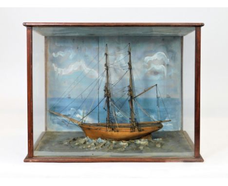 SHIP DIORAMA. A cased ship diorama showing a model of a brig c.1870. The hull of solid pine construction resting on a painted