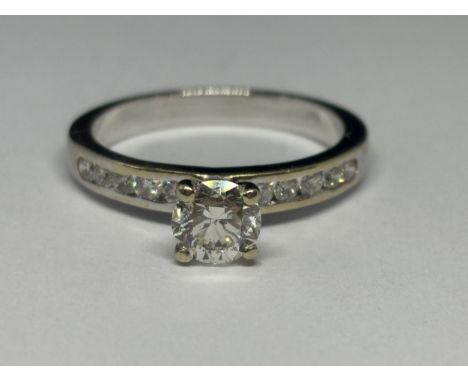 AN 18 CARAT WHITE GOLD RING WITH A 0.8 CARAT CENTRE BRILLIANT ROUND CUT DOIAMOND WITH 0.2 CARAT IN TEN STONES TO THE SHOULDER