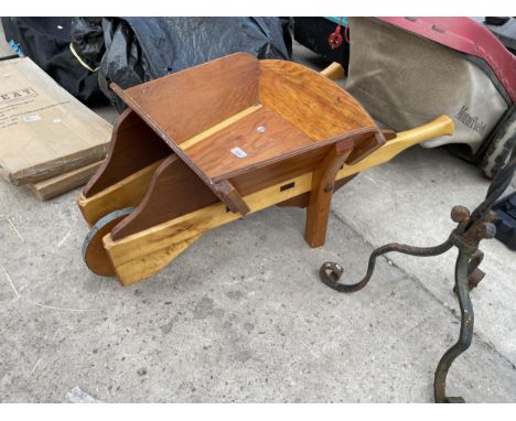 A SMALL WOODEN WHEEL BARROW PLANTER