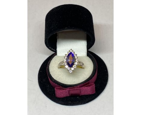 A MARKED SILVER DRESS RING WITH AN AMETHYST COLOURED STONE SURROUNDED BY CLEAR STONES IN A PRESENTATION BOX