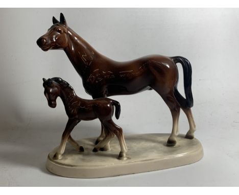 A VINTAGE HERTWIG KATZHUTTE GERMAN PORCELAIN FIGURE OF A BROWN HORSE MARE WITH ITS FOAL IN A GLOSSY FINISH