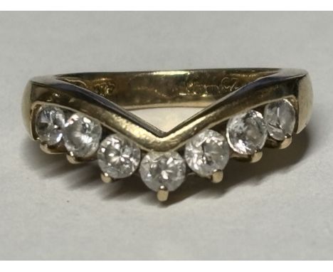A MARKED 9 CARAT GOLD WISHBONE RING WITH SEVEN STONES SIZE K