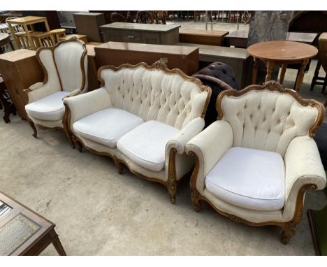 A CONTINENTAL STYLE BUTTON BACK SETTEE AND CHAIR WITH FOLIATE CARVING AND SIMILAR WINGED CHAIR