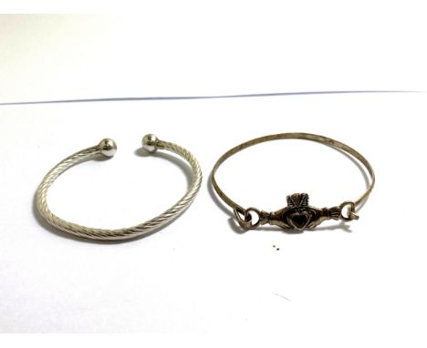 TWO MARKED SILVER BANGLES TO INCLUDE AN IRISH CLADDAGH CELTIC KNOT WITH RED STONE