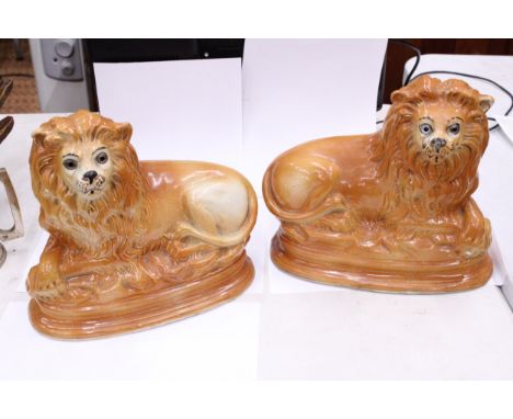 A PAIR OF VINTAGE STAFFORDSHIRE LIONS WITH GLASS EYES, HEIGHT 24CM, WIDTH 28CM