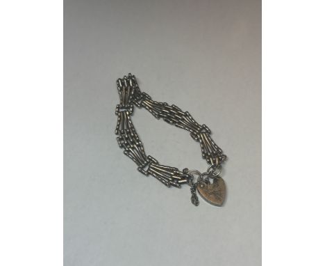 A FOUR BAR SILVER GATE BRACELET WITH HALLMARKED LONDON SILVER HEART PADLOCK