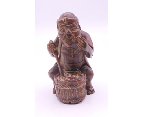 A netsuke formed as a man with a barrel.  6 cm high. 