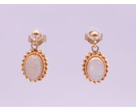 A pair of 9 ct gold opal drop earrings.  1 cm high. 1.4 grammes total weight.