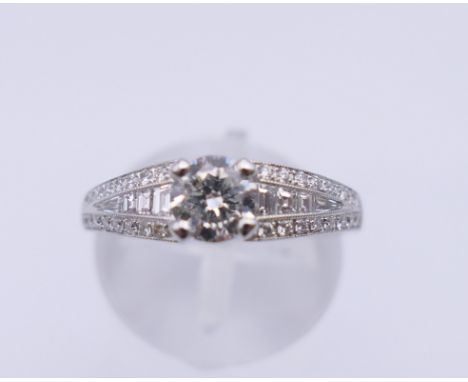 An 18 ct white gold diamond ring set with approximately 0.5 carat centre stone, with multi set diamonds along the shoulders. 