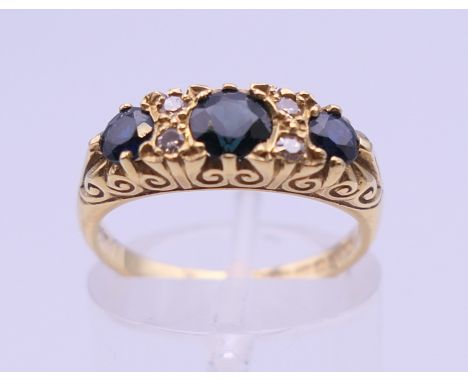 An 18 ct gold diamond and sapphire ring. Ring size L/M. 5 grammes total weight.