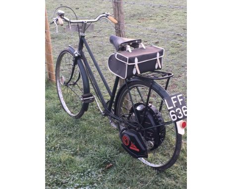 A 1951 Cyclemaster, registration number LFF 636, green.  This Cyclemaster has been fitted to a Triumph bicycle and has formed