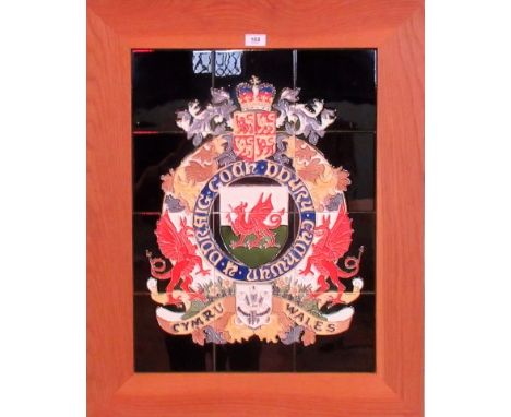 A composite pottery tile panel with a tube lined and enamelled coat of arms for Wales, 61cm x 46cm.