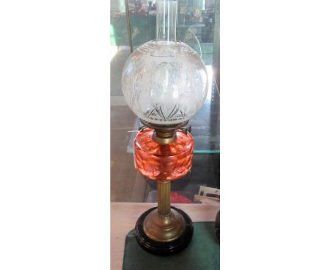 A Victorian pedestal oil lamp with ribbed pink glass reservoir and a duplex burner system with acid etched diffuser.
