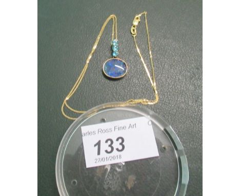An opal doublet pendant, suspended from a three stone topaz drop with 9ct gold mounts and a 9ct trace link chain.