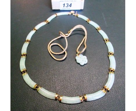 A gold mounted pale jade necklace, comprising carved jade panels with chain link and gold clasp, together with a small carved