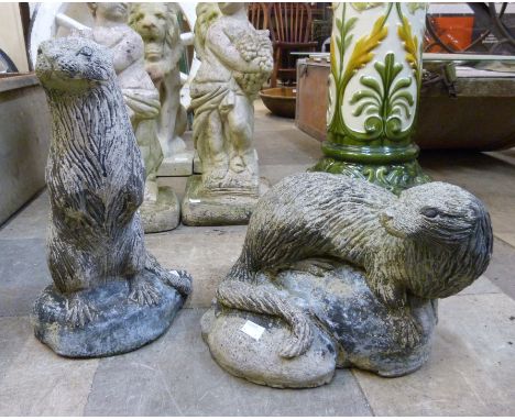 Two concrete garden figures of otters 