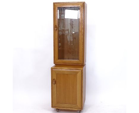 An Ercol light elm narrow display cabinet with cupboard base, W43cm 