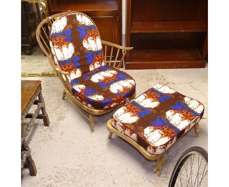 An Ercol stick-back armchair, and matching footstool, with loose cushions (A/F) 