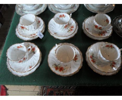 An early 20th century part-tea service, comprising: six trios, having floral sprays on an ivory ground with gilt finish, numb