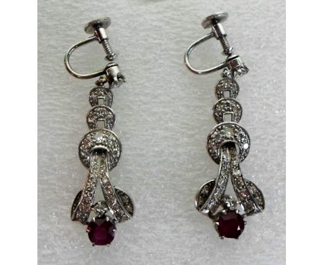 A pair of Art Deco ruby and diamond earrings, three graduated diamond set hoops suspended from a single stone diamond and ter