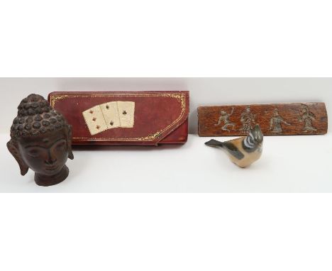 A vintage leather case for two decks of cards; a Royal Copenhagen figure of a bird; a cast metal head and an oriental wooden 