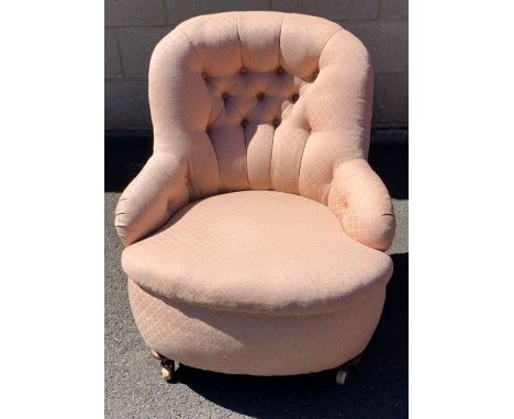 A Victorian button back open armchair, with a shell shaped back, mahogany legs and ceramic casters 