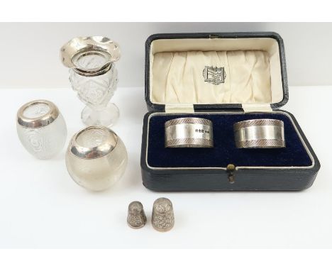 A cased pair of silver napkin rings with engine turned decoration, Chester, 1929, E J Trevitt &amp; Sons; a silver rimmed bud