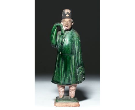 Ming Dynasty, ca. 1368 to 1644 CE. This is a small glazed, molded ceramic figure of a man wearing a green robe and a fez-like