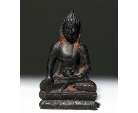 Nepal, 18th to 19th century CE. Well-worn carved stone image of Buddha, seated in full lotus position, right hand in proper B