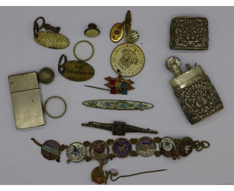 A white metal cased lighter, badges, etc.