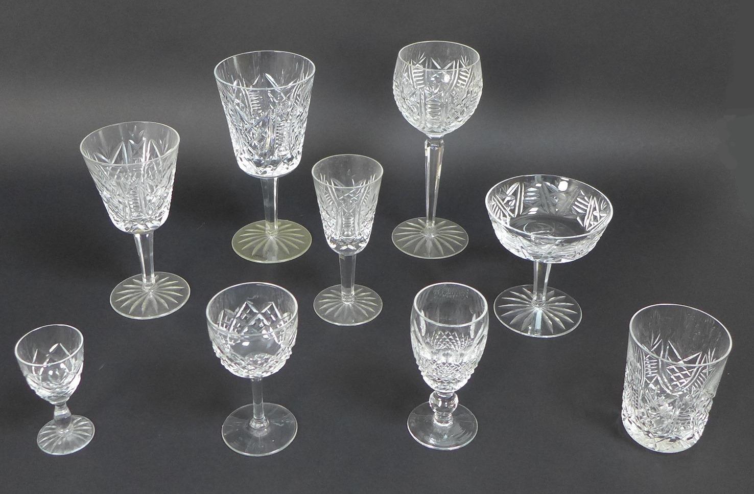 A large collection of Waterford Crystal drinking glasses, including a