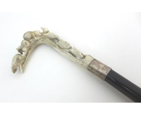 A walking stick with rosewood shaft, antler handle carved as seven rodents on a branch, silver collar and brass ferrule, 86cm