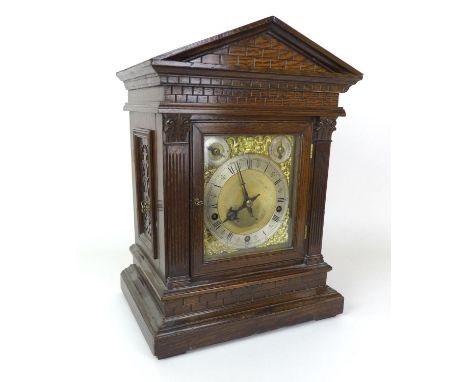 A late Victorian oak cased mantel clock, with musical movement stamped ‘W+H SGL’ chiming on four coils, the dial with silvere