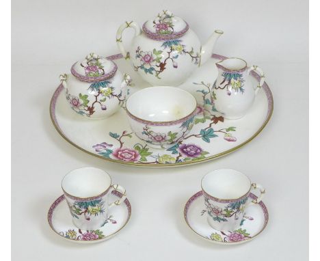 A Victorian Royal Worcester porcelain tete a tete tea service, decorated in Chinese style with prunus blossom, a pink border 