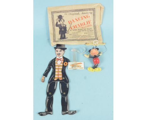 A vintage Charlie Chaplin 'Dancing' card figure with original bag (lacking his left arm), plus a Mickey Mouse puppet