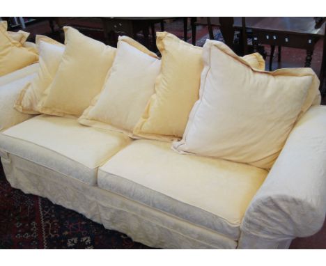  A modern three seater sofa   with loose yellow covers.230cm wide. 