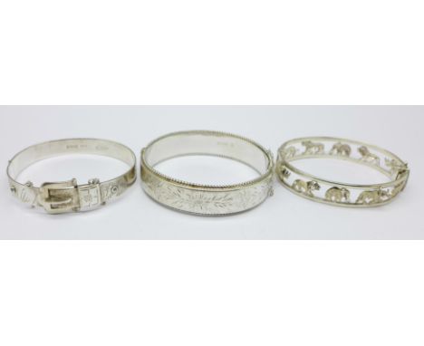 Two hallmarked silver bangles and one other silver bangle decorated with wild animals, 62g 