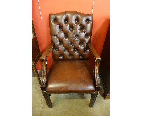 A mahogany and brown leather library armchair