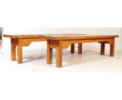 A pair of later 20th century light oak benches. The benches having single plank seat bases, shaped framing and raised on soli