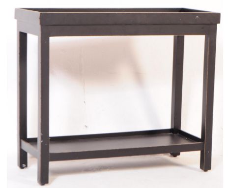 A contemporary black ebonised OKA Narrow Jet side / console table. The table being raised on squared legs joined by a lower t