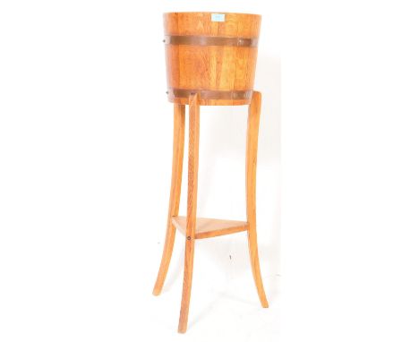 Early 20th century Edwardian brass and oak ice bucket jardini&egrave;re. Of circular form with brass banding on tripod legs u