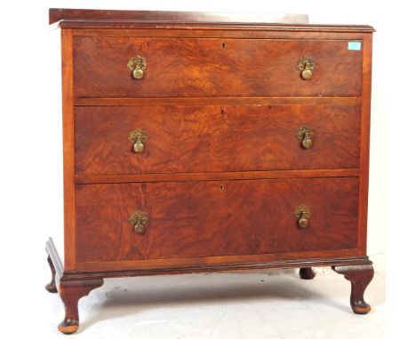 A 1930's Art Deco walnut chest of three drawers. With chamfered edging, brass decorative drop swing handles, all raised upon 
