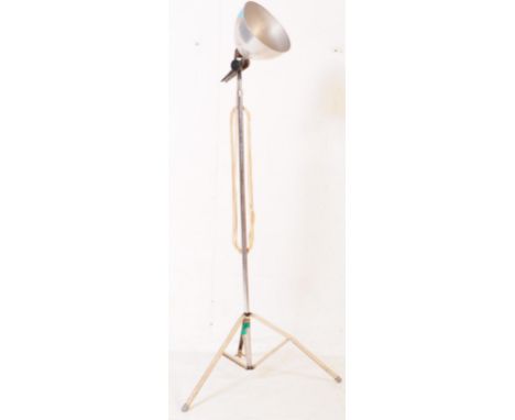 A vintage mid 20th century chrome metal tripod standing lamp light. Having a conical shade with adjustable tilt movement. On 