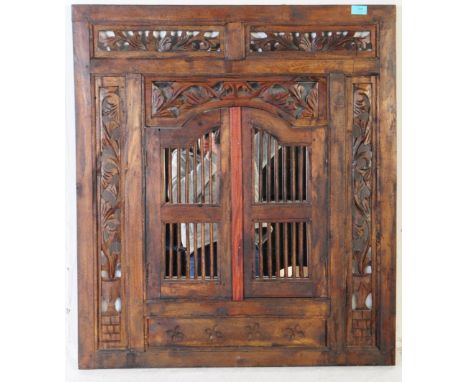 A 20th century Anglo-Indian colonial hardwood fretwork carved and pierced hanging wall mirror. The mirror set behind folding 