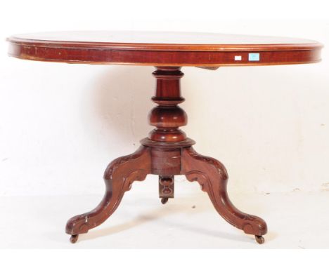 A Victorian 19th century mahogany tilt top round pedestal table. The occasional table having a round tilt top over carved det