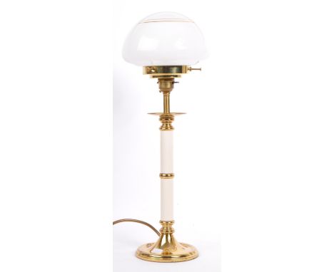 A contemporary Art Deco style table lamp light. Having dome opaque glass shade with gilt rim, with light fixing to top on cen