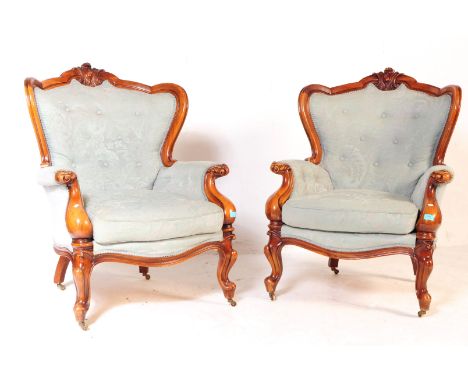 A pair of 19th century Victorian revival lounge fireside library armchairs. Mahogany construction with carved fleur de lys to