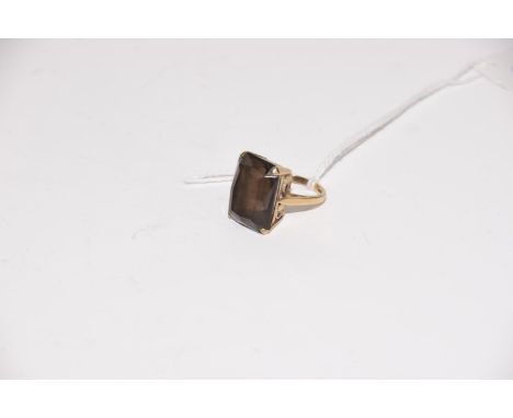 A 9ct gold smoky quartz dress ringThe rectangular shape smoky quartz within a four claw setting, hallmarks for Birmingham, ri