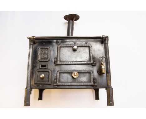 A scarce French late 19thc miniature cast iron cooking Range. With a makers mark 'ANGne Mon Godin A Guise' An impressive func