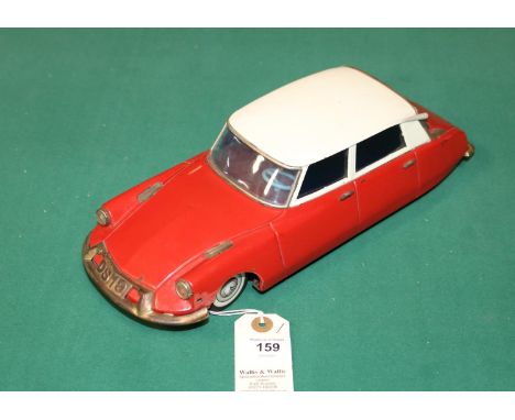 A scarce early 1960's Bandai battery powered 1:18 scale tinplate model of a Citroen ID DS 4-door saloon. In red with cream ro